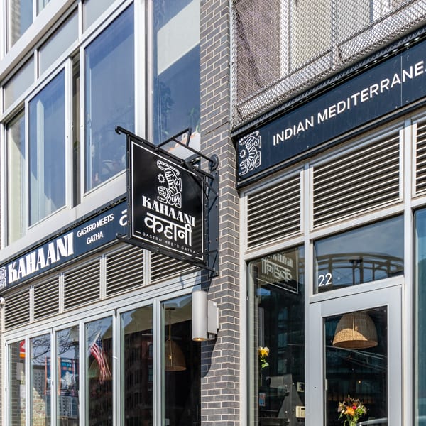 Exterior view of Kahaani restaurant, featuring a black sign with white text and a tiger logo.